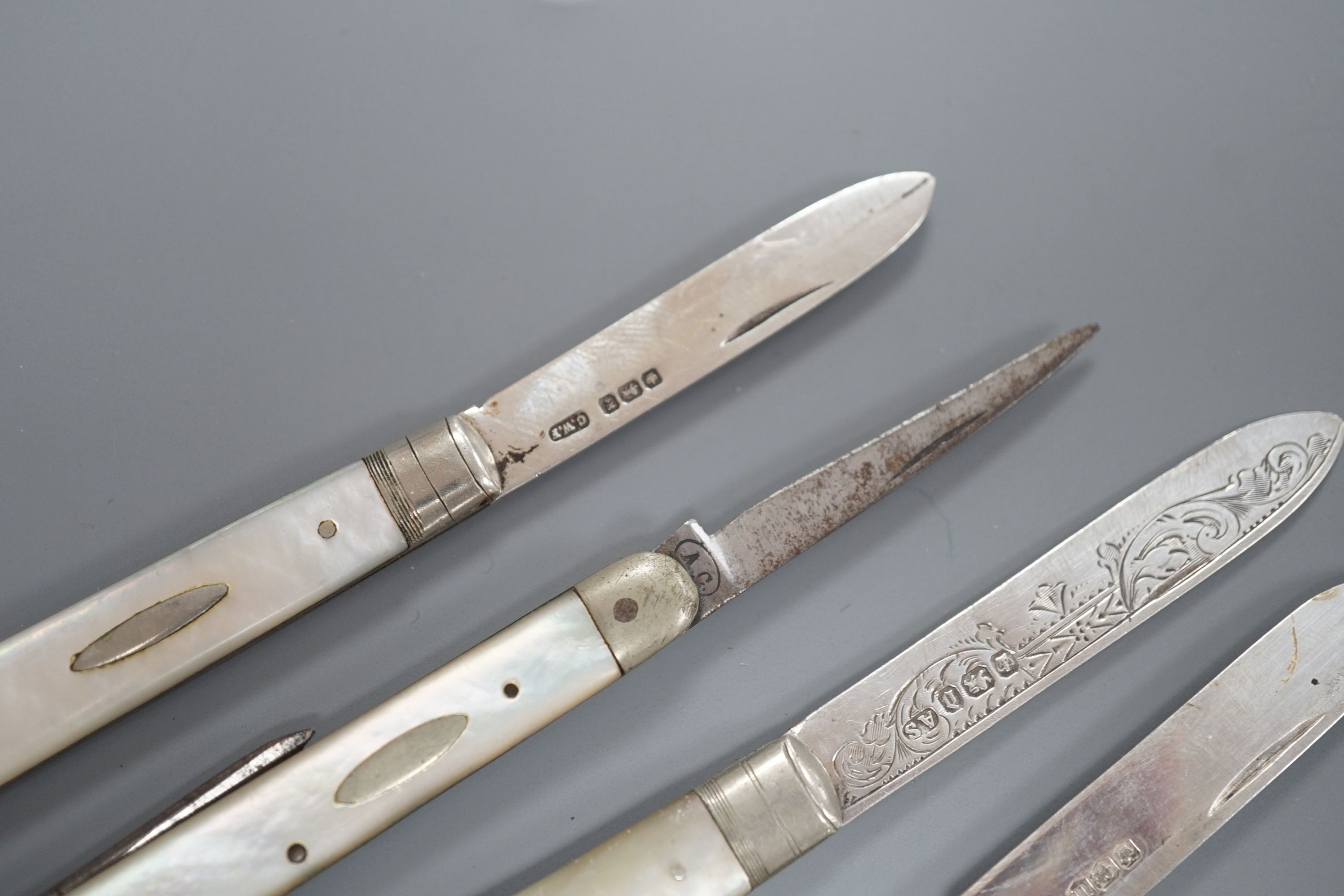 Three assorted mother of pearl mounted silver bladed fruit knives, one other penknife and two commemorative pocket knives.
